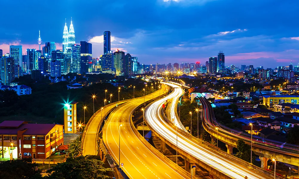 Kuala Lumpur skyline and illuminated highways at dusk